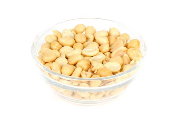istock Roasted and salted peanuts in glass bowl over white 1059682714