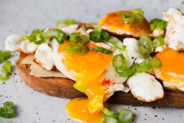 istock Toast with fried egg,flowing yolk and onion shoots. 1059683936