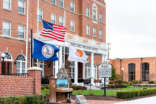 Wytheville, USA - April 19, 2018: Small town village signs flags for historic famous Bolling Wilson boutique hotel in southern south Virginia, historic brick buildings