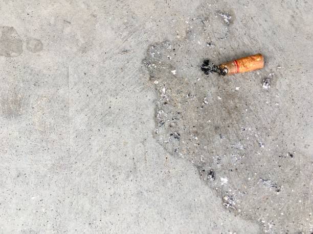 istock One cigarette on the cement floor. 1059704250