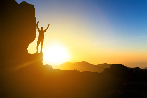 istock Man hiking silhouette in mountains, ocean and sunset 1059713498