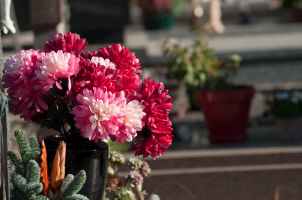 Flowers in a cemetery with large maple trees in the background, in autumn (Beloeil, Quebec, Canada)