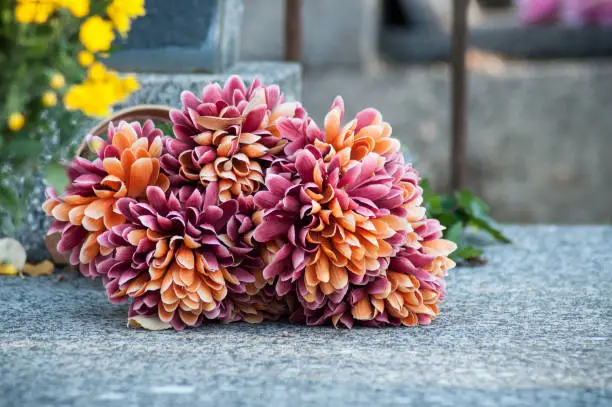 Photo of artificial flowers on tomb in cemetery