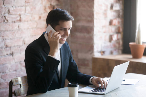 istock Happy businessman talking on the phone while reading news. 1059736090