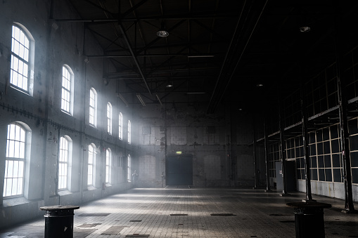 Sunlight shining throuh the windows of an old abandoned industrial warehouse building