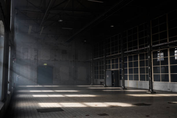 sonnenlicht throuh die fenster eines altbaus verlassene industriehalle - alte fabrik stock-fotos und bilder