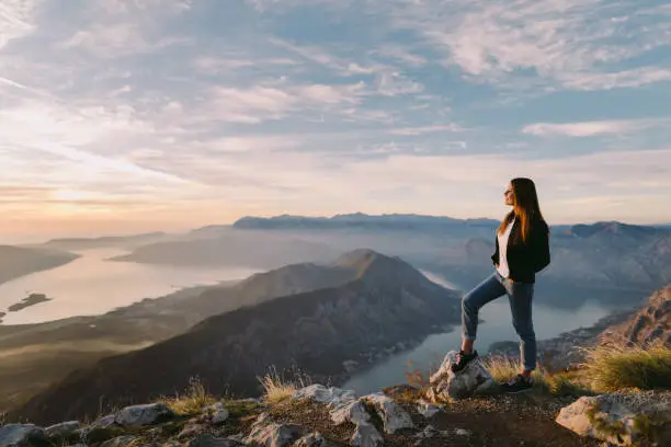 woman relax in mountains at sunset with beautiful view. Picturesque landscape background.