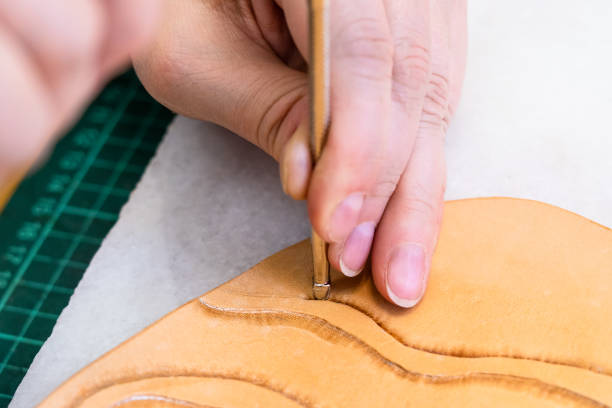 istock craftsman stamps the relief on surface of leather 1059761322