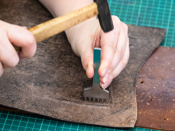 istock craftsman punches a leather detail for handbag 1059761444