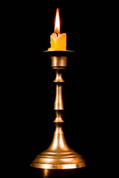 istock Lit candle on a brass candlestick 1059764616