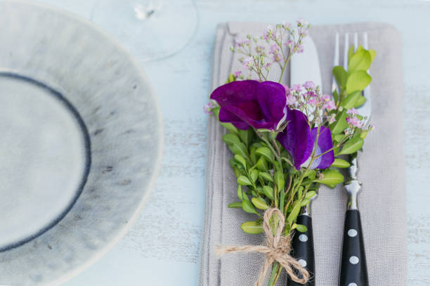 istock Rustic table setting with purple flowers on light wooden table. 1059766550