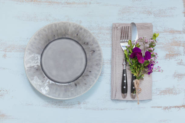 istock Rustic table setting with purple flowers on light wooden table. 1059766556