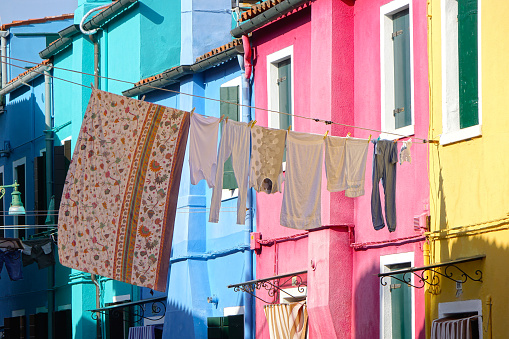 CLOSE UP: Laundry drying in summer winds blowing through the streets of Burano.