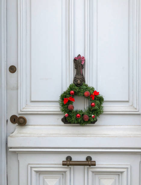 istock Christmas Wreath with the red apples on a white door 1059770362
