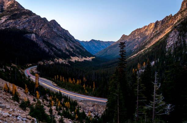 ノースカスケード国立公園、ワシントン州米国の北カスケード高速道路で車の光跡の夕日のシーン - north cascades national park glacier vertical photography ストックフォトと画像