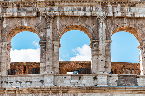 Rome, Italy closeup of historic city Colosseum architecture windows blue sky, sunny summer day, looking up at stone walls of Amphitheatre