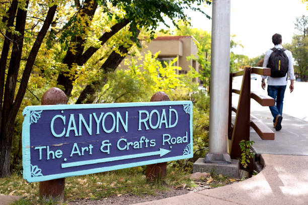 Santa Fe, NM: Canyon Road Sign Santa Fe, NM: A wooden sign with blue print pointing to Canyon Road, a hub of the vibrant art market in Santa Fe, NM. canyon road stock pictures, royalty-free photos & images