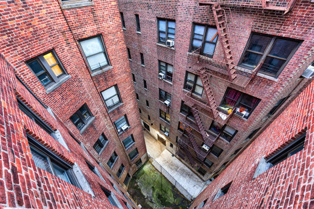 alto ángulo, mirando hacia abajo vista en condominio apartamento de ladrillo iluminada edificio arquitectura en alturas de fordham center, nyc, bronx, manhattan, nueva york con escapes del fuego, windows - building exterior mid atlantic usa usa night fotografías e imágenes de stock