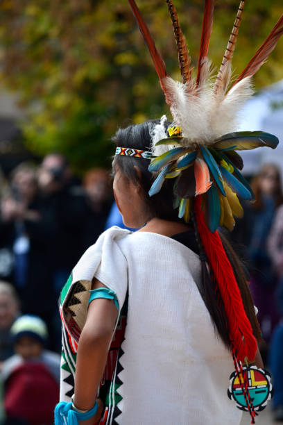Indigenous Peoples Day Santa Fe, NM - October 8, 2018: A young Native-American girl from Pojoaque Pueblo in New Mexico, wearing a tropical bird feather headdress at Indigenous Peoples Day in Santa Fe, New Mexico. indigenous peoples day stock pictures, royalty-free photos & images