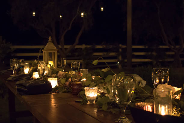Outdoor Night Table Setting for Wedding or Party with Candles and Plants stock photo