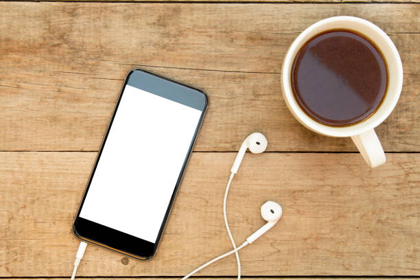 istock Smartphone with headphones and coffee on wooden table. 1059793954