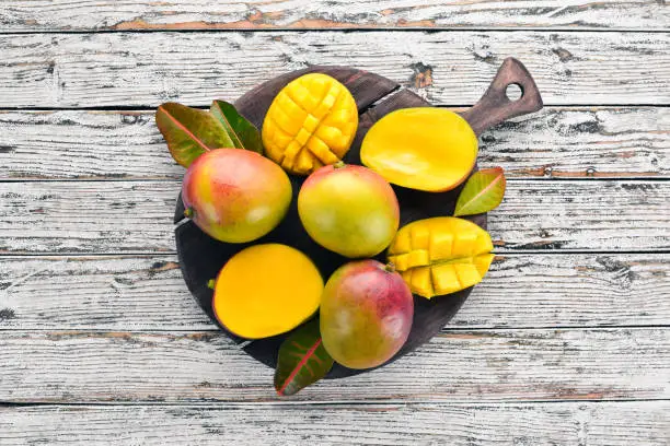 Mango. On a white wooden background. Tropical Fruits. Top view. Free copy space.