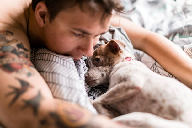 istock Man With Tattoos Embracing his Dog 1059805108