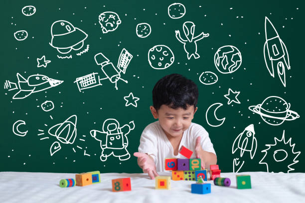 istock Asian kid learning by playing with his imagination about science and space adventure, hand drawn on the green chalkboard, education back to school and discovery concept. 1059823100