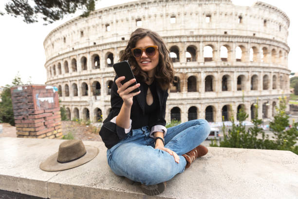 tourisme au repos et tenant selfie devant le colisée - international landmark italy amphitheater ancient photos et images de collection