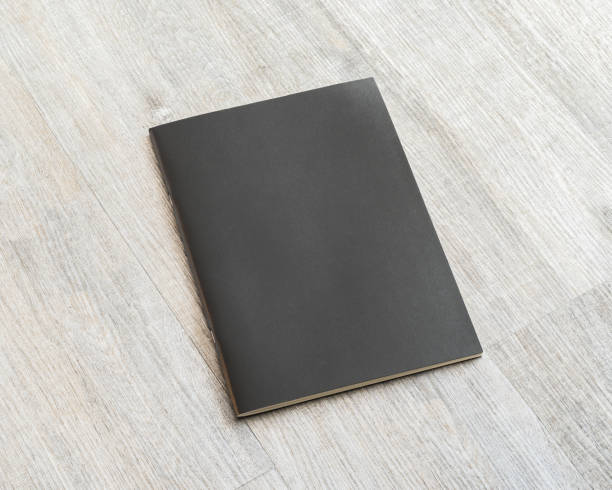 istock Book mockup blank black A4 leather cover for magazine, booklet, brochure, menu, diary mock-up design template on wooden table background 1059834994