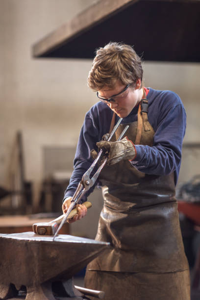istock Young blaksmith working with hot metal in a workshop 1059835900