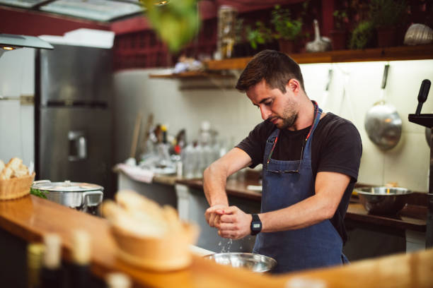 istock Chef seasoning ingredients in kitchen area of restaurant 1059836086