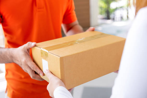 istock Courier service delivery man giving parcel box to customer 1059836498