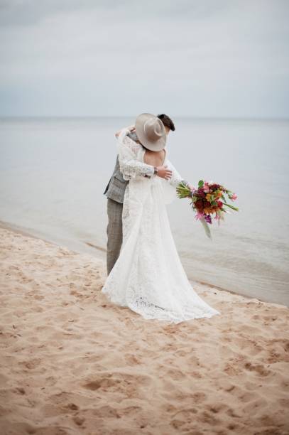 istock Bride And Bridegroom Embracing At Beach During Wedding Ceremony 1059860594