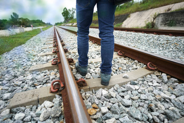 uomo a piedi seguire concetto ferroviario andare avanti per l'obiettivo - rack railway foto e immagini stock