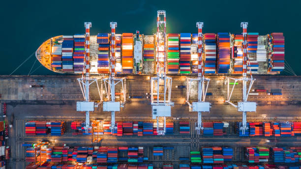 istock Aerial top view crane shipping container at night, cargo container ship carrying container import and export business logistic and transportation. 1059876314