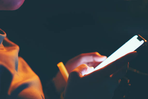 istock Texting cellphone or Using smartphone at night , Social Networking, finger touch white screen Mobile telephone in the darkroom 1059885422