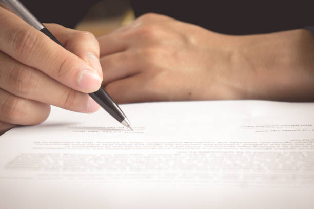 istock Man is holding pen in hand and writing / signing on contract peper 1059898400