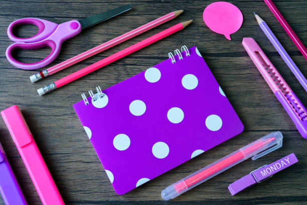 istock Welcome back to school concept.Education accessories for lean scissors, pencil,cutter,highlighter pen, ultra violet color notebook polka dot pattern on wooden background.Flat lay with copy space. 1059901982