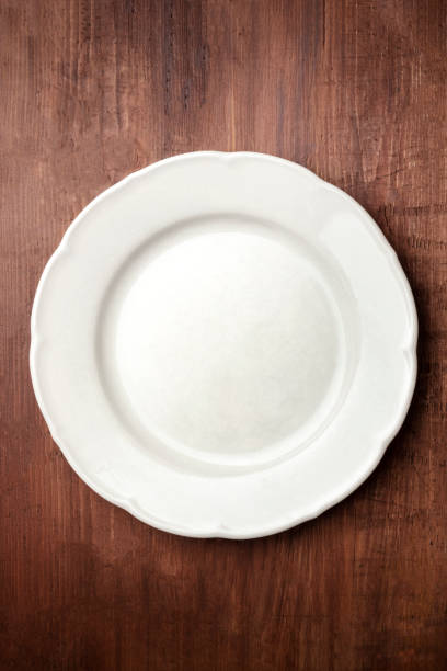 White plate, shot from the top on a dark rustic wooden background with copy space