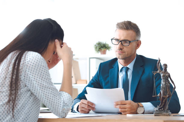 istock lawyer holding papers and working with upset client 1059944136