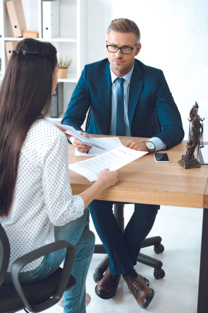 istock lawyer and client looking at each other while working with contract in office 1059944140