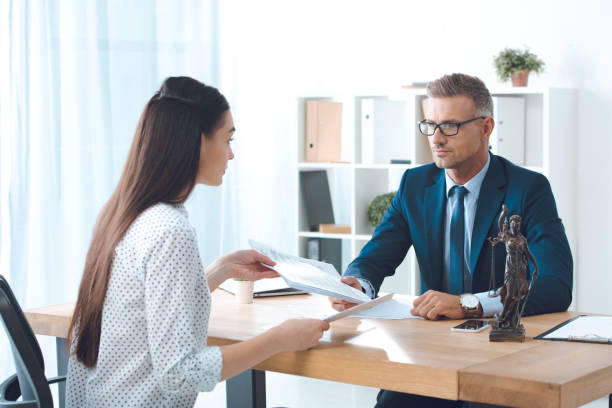 istock lawyer and client holding papers in office 1059944150