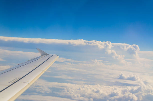istock Picture of airplane wing, cloudy sky from porthole 1059944190