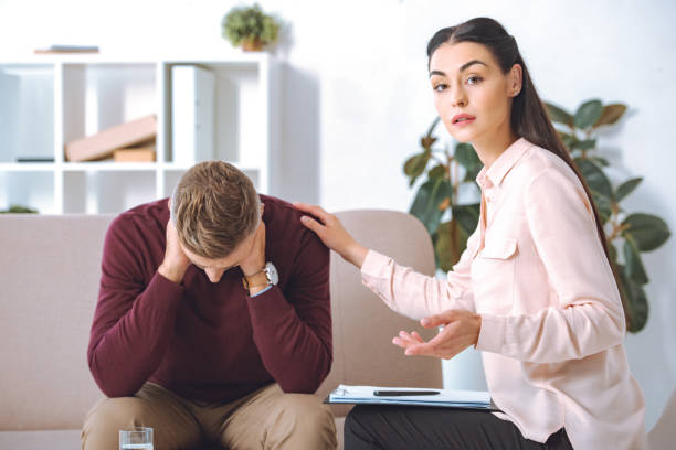 istock psychotherapist looking at camera while supporting upset patient in office 1059944282