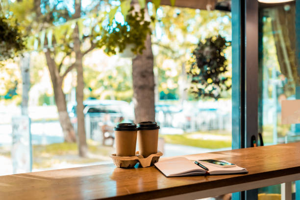 istock two coffee in paper cups, open notebook with pen on cafe counter 1059944984