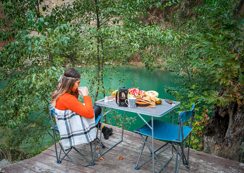 Young woman having breakfast on a camping place near Antalya, Turkey