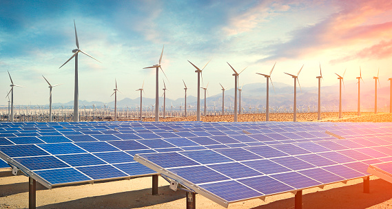 Solar panels and wind turbines in the desert producing renewable energy