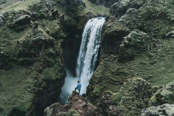 istock Man standing near the waterfall in Iceland 1059963090