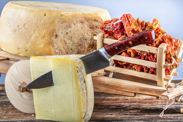 cheese wheel on wooden table - cheese wheel cheese cheddar wheel imagens e fotografias de stock